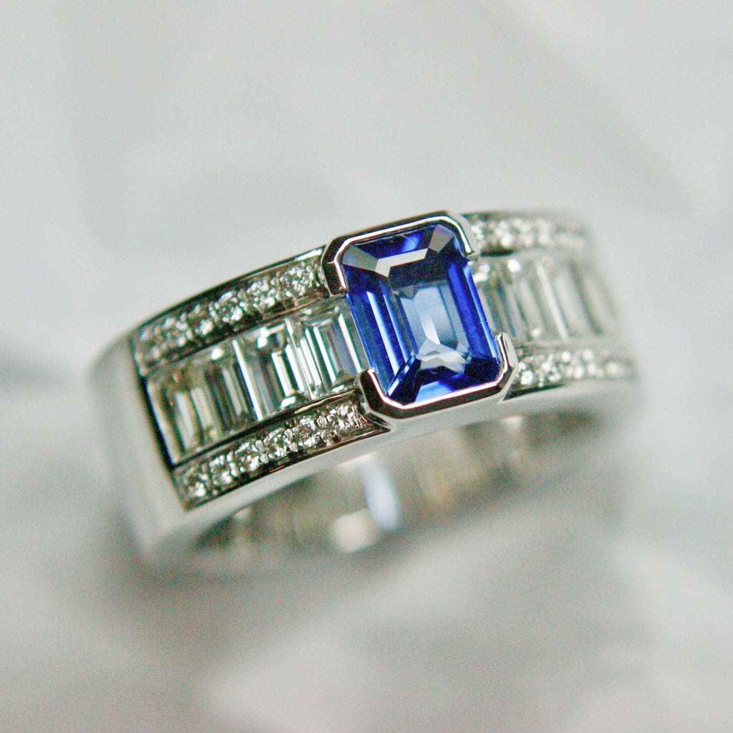 Emerald-Cut Sapphire Ring with Baguette Diamonds in White Metal Rail Setting